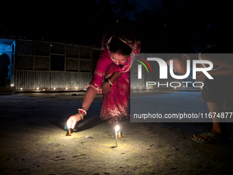 In Feni, Bangladesh, on October 17, 2024, a mother and child light oil lamps during the 'Deep Utsav or Light festival' before the Diwali fes...