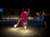 In Feni, Bangladesh, on October 17, 2024, a mother and child light oil lamps during the 'Deep Utsav or Light festival' before the Diwali fes...