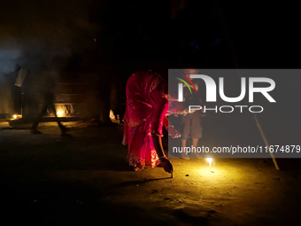 In Feni, Bangladesh, on October 17, 2024, a mother and child light oil lamps during the 'Deep Utsav or Light festival' before the Diwali fes...