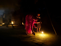 In Feni, Bangladesh, on October 17, 2024, a mother and child light oil lamps during the 'Deep Utsav or Light festival' before the Diwali fes...