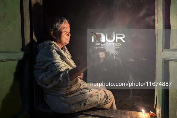 A Hindu elderly woman plays with light during the 'Deep Utsav or Light festival' before the Diwali festival in Feni, Bangladesh, on October...