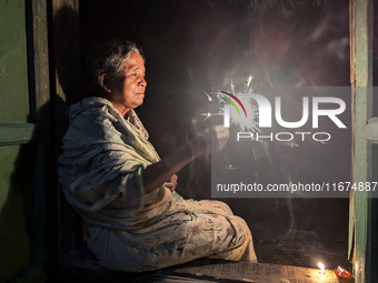 A Hindu elderly woman plays with light during the 'Deep Utsav or Light festival' before the Diwali festival in Feni, Bangladesh, on October...