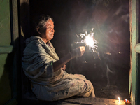 A Hindu elderly woman plays with light during the 'Deep Utsav or Light festival' before the Diwali festival in Feni, Bangladesh, on October...