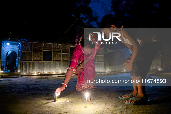 Mother and child play with light during the 'Deep Utsav or Light festival' before the Diwali festival in Feni, Bangladesh, on October 17, 20...