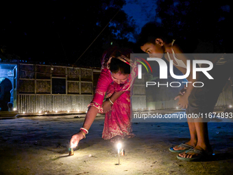 Mother and child play with light during the 'Deep Utsav or Light festival' before the Diwali festival in Feni, Bangladesh, on October 17, 20...