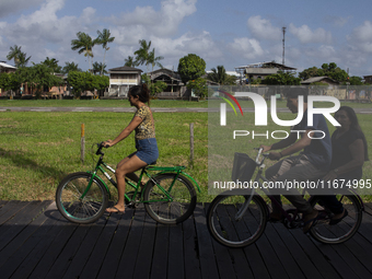 People ride bicycles on stilts in Afua, Para, Brazil, on September 29, 2024. (