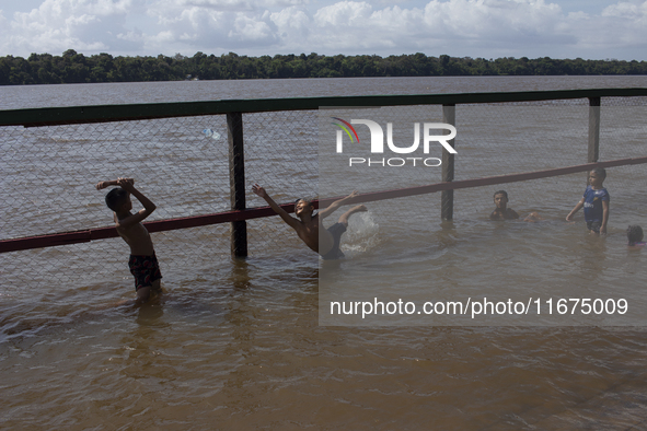 Children play at the municipal spa located at the mouth of the Amazon River in Afua, Para, Brazil, on September 29, 2024. 