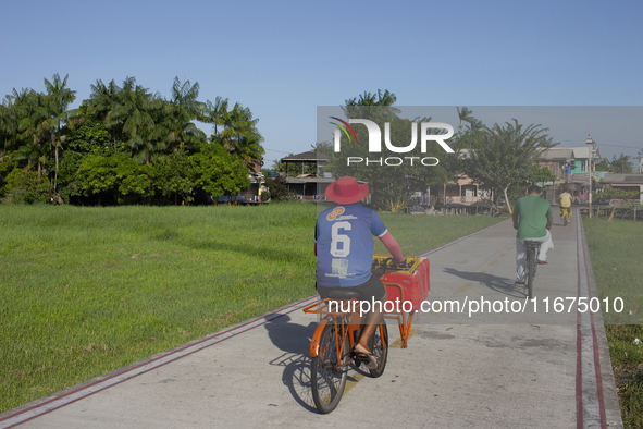 People ride bicycles in the town of Afua, located at the mouth of the Amazon River, in Afua, Para, Brazil, on September 29, 2024. 