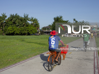 People ride bicycles in the town of Afua, located at the mouth of the Amazon River, in Afua, Para, Brazil, on September 29, 2024. (