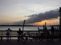 People and their bicycles watch the sunset on the banks of the Amazon River in Afua, Para, Brazil, on September 29, 2024. (