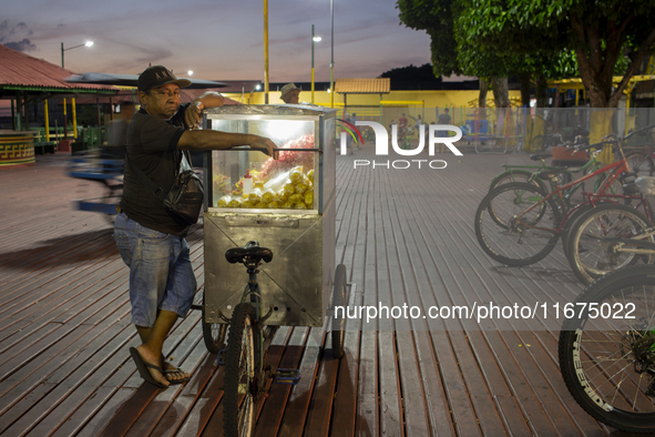 A popcorn vendor stands in the town square at night on the banks of the Amazon River in Afua, Para, Brazil, on September 29, 2024. 