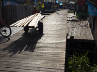 A man carries wood used to build the streets of the city of Afua in Afua, Para, Brazil, on October 1, 2024. (