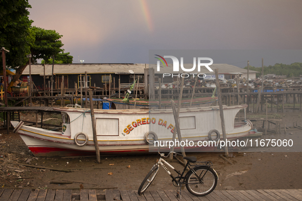 A boat and a bicycle appear at the mouth of the Amazon River with a rainbow in the background in Afua, Para, Brazil, on October 1, 2024. 