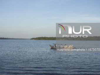 A typical Amazonian boat sails at the mouth of the Amazon River in Afua, Para, Brazil, on October 2, 2024. (