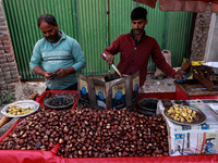 Vendors sell chestnuts and wait for customers in Srinagar, Jammu and Kashmir, India, on October 17, 2024. (