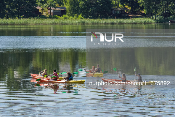 People kayak on rented kayaks on Sudomie Lake in the Cassubia region, Poland, on July 20, 2024. 