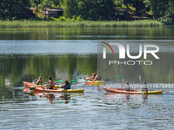 People kayak on rented kayaks on Sudomie Lake in the Cassubia region, Poland, on July 20, 2024. (