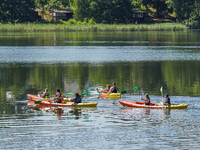 People kayak on rented kayaks on Sudomie Lake in the Cassubia region, Poland, on July 20, 2024. (