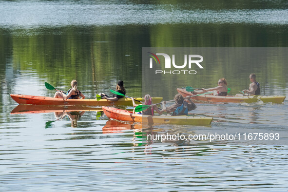 People kayak on rented kayaks on Sudomie Lake in the Cassubia region, Poland, on July 20, 2024. 