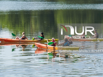 People kayak on rented kayaks on Sudomie Lake in the Cassubia region, Poland, on July 20, 2024. (