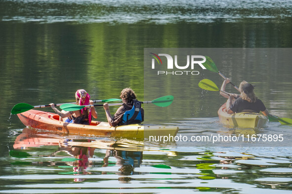 People kayak on rented kayaks on Sudomie Lake in the Cassubia region, Poland, on July 20, 2024. 