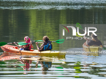 People kayak on rented kayaks on Sudomie Lake in the Cassubia region, Poland, on July 20, 2024. (