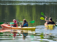 People kayak on rented kayaks on Sudomie Lake in the Cassubia region, Poland, on July 20, 2024. (