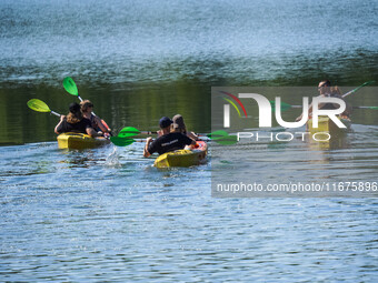 People kayak on rented kayaks on Sudomie Lake in the Cassubia region, Poland, on July 20, 2024. (