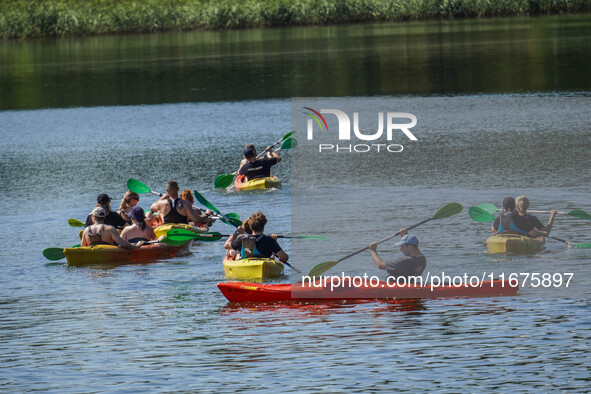 People kayak on rented kayaks on Sudomie Lake in the Cassubia region, Poland, on July 20, 2024. 