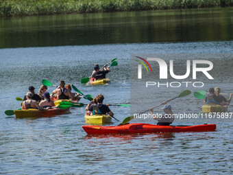 People kayak on rented kayaks on Sudomie Lake in the Cassubia region, Poland, on July 20, 2024. (