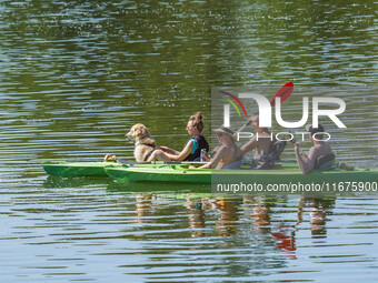 People kayak on rented kayaks on Sudomie Lake in the Cassubia region, Poland, on July 20, 2024. (