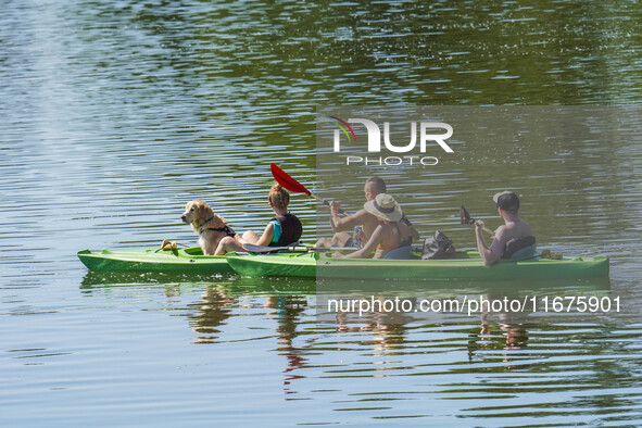 People kayak on rented kayaks on Sudomie Lake in the Cassubia region, Poland, on July 20, 2024. 