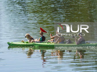 People kayak on rented kayaks on Sudomie Lake in the Cassubia region, Poland, on July 20, 2024. (