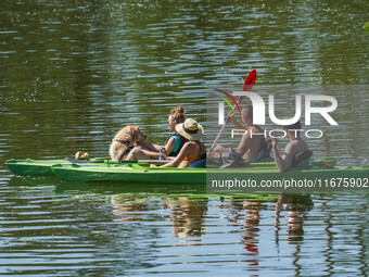 People kayak on rented kayaks on Sudomie Lake in the Cassubia region, Poland, on July 20, 2024. (