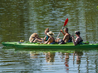 People kayak on rented kayaks on Sudomie Lake in the Cassubia region, Poland, on July 20, 2024. (