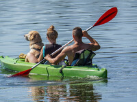 People kayak on rented kayaks on Sudomie Lake in the Cassubia region, Poland, on July 20, 2024. (