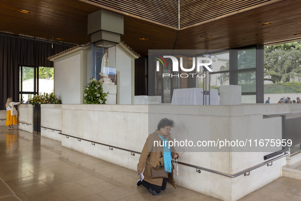 In Lisbon, Portugal, on October 17, 2024, a person walks on her knees near the image of the Virgin inside the chapel of the Sanctuary of Fat...