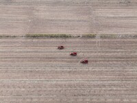 Workers drive a fertilizer spreader to distribute organic fertilizer in preparation for wheat planting in a high-standard farmland in Liaoch...