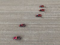 Workers drive a fertilizer spreader to distribute organic fertilizer in preparation for wheat planting in a high-standard farmland in Liaoch...