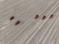 Workers drive a fertilizer spreader to distribute organic fertilizer in preparation for wheat planting in a high-standard farmland in Liaoch...