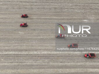 Workers drive a fertilizer spreader to distribute organic fertilizer in preparation for wheat planting in a high-standard farmland in Liaoch...