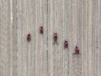 Workers drive a fertilizer spreader to distribute organic fertilizer in preparation for wheat planting in a high-standard farmland in Liaoch...