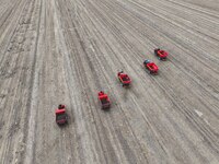 Workers drive a fertilizer spreader to distribute organic fertilizer in preparation for wheat planting in a high-standard farmland in Liaoch...