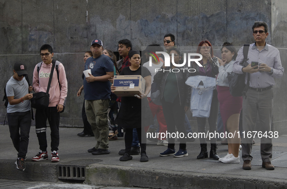 A group of passers-by watches a police operation after an attack on Diana Sanchez Barrios, leader of traders in the Historic Centre of Mexic...