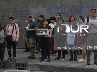 A group of passers-by watches a police operation after an attack on Diana Sanchez Barrios, leader of traders in the Historic Centre of Mexic...