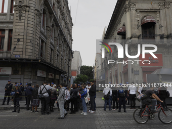 A group of passers-by watches a police operation after an attack on Diana Sanchez Barrios, leader of traders in the Historic Centre of Mexic...