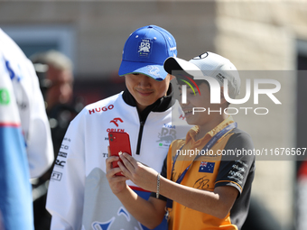 Yuki Tsunoda takes a photo with a young fan in the paddock at Circuit of the Americas in Austin, Texas, on October 17, 2024. (