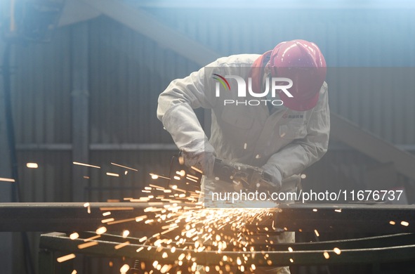 A worker polishes machinery parts for export at a machinery manufacturing workshop in Hangzhou, Zhejiang province, China, on October 18, 202...