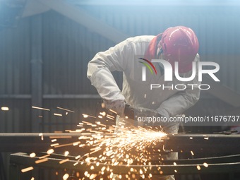 A worker polishes machinery parts for export at a machinery manufacturing workshop in Hangzhou, Zhejiang province, China, on October 18, 202...