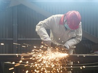 A worker polishes machinery parts for export at a machinery manufacturing workshop in Hangzhou, Zhejiang province, China, on October 18, 202...